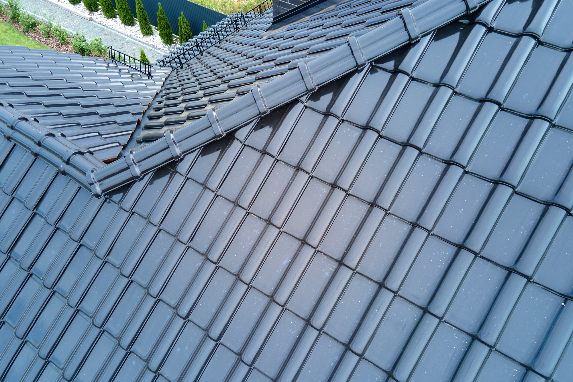 Closeup of house roof top covered with shiny ceramic shingles